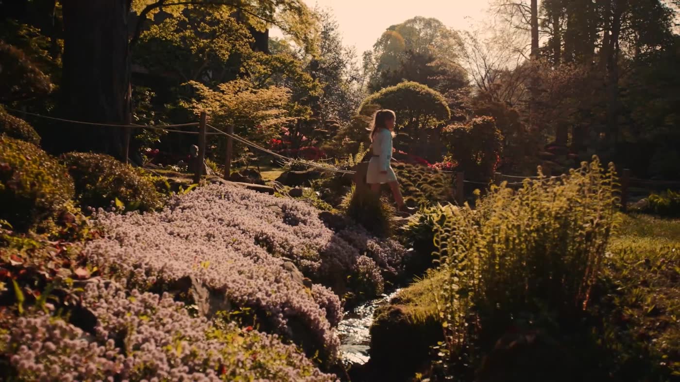 Une silhouette blanche au loin dans le parc, au milieu des azalées. Le premier plan du film ne montre pas de judo.